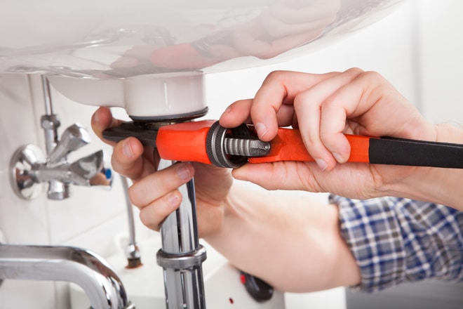 Picture of handyman repairing a sink pipe